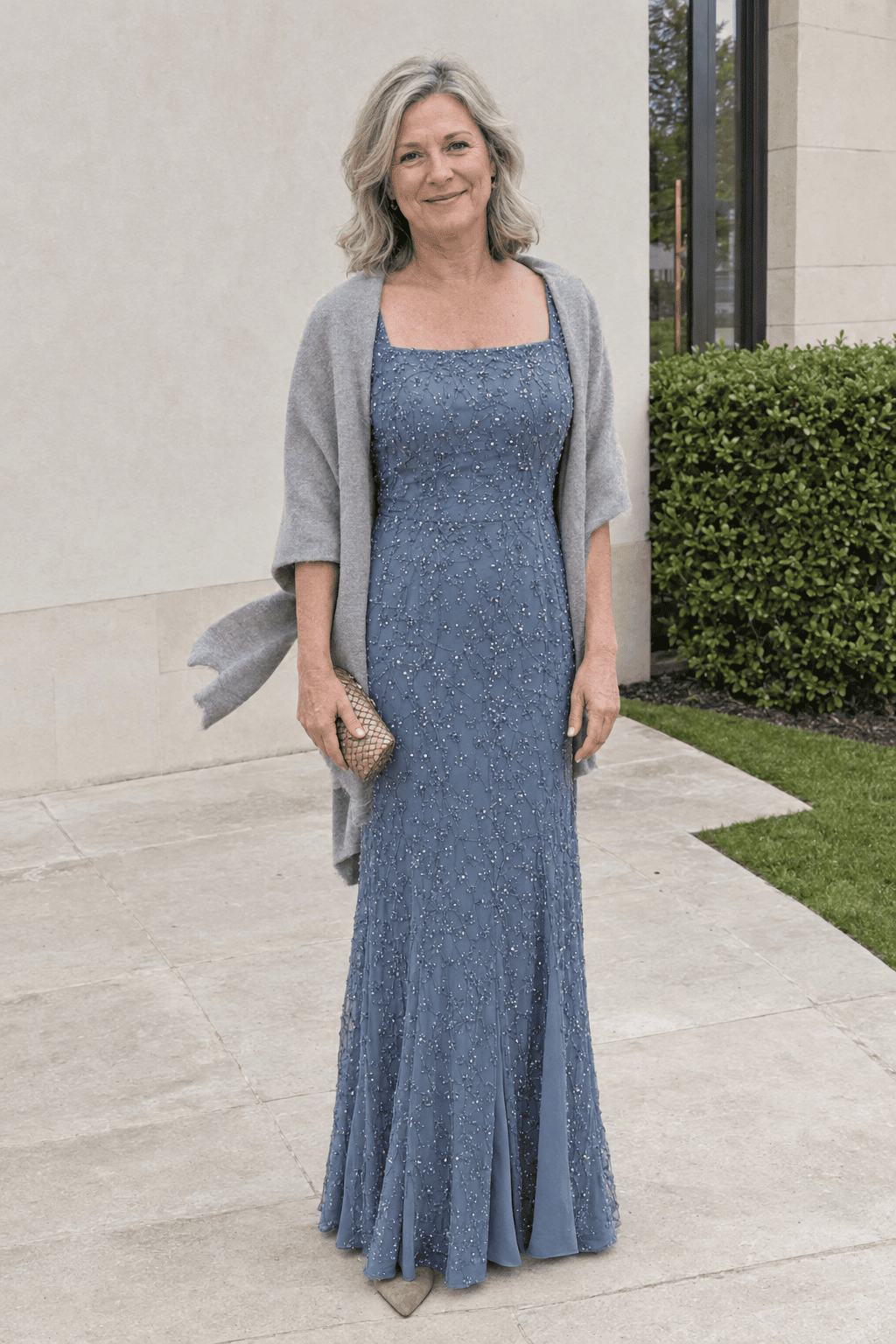 mother of the bride outfit in dusty blue: beaded short-sleeve gown with a gray cashmere wrap, tan suede block-heel pumps and a soft gold clutch