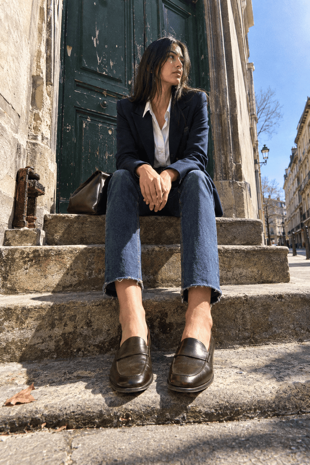 capsule wardrobe outfit for a casual office: navy wool blazer, oversized white cotton shirt, dark indigo jeans and dark brown loafers