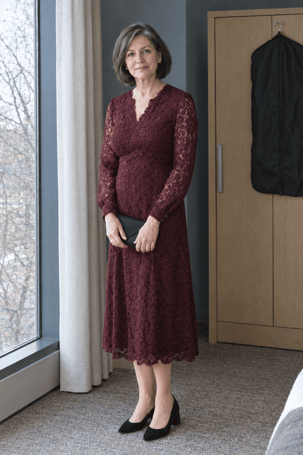 mother of the bride outfit in burgundy: dark cherry long-sleeve lace tea dress to mid-calf with black suede block-heel pumps and a black satin clutch