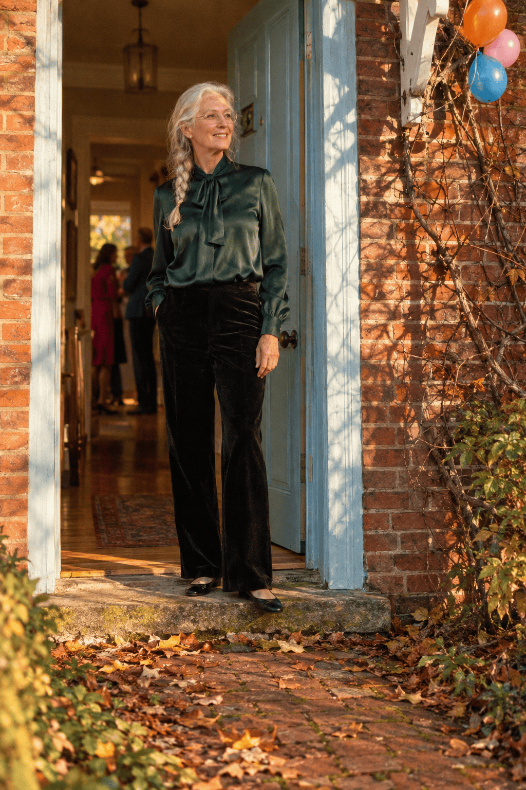 birthday party at home outfit for women in their 70s: forest green silk tie-neck blouse, black velvet straight-leg trousers and black leather ballet flats