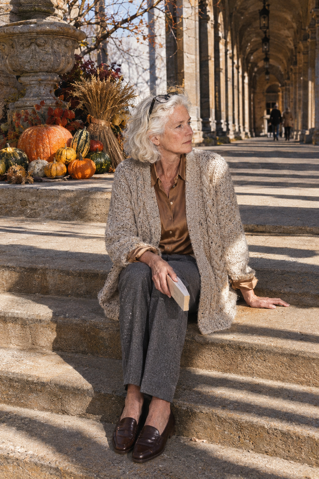 women over 60 thanksgiving outfit: cream cable cardigan over tan silk shirt with grey wool-blend trousers