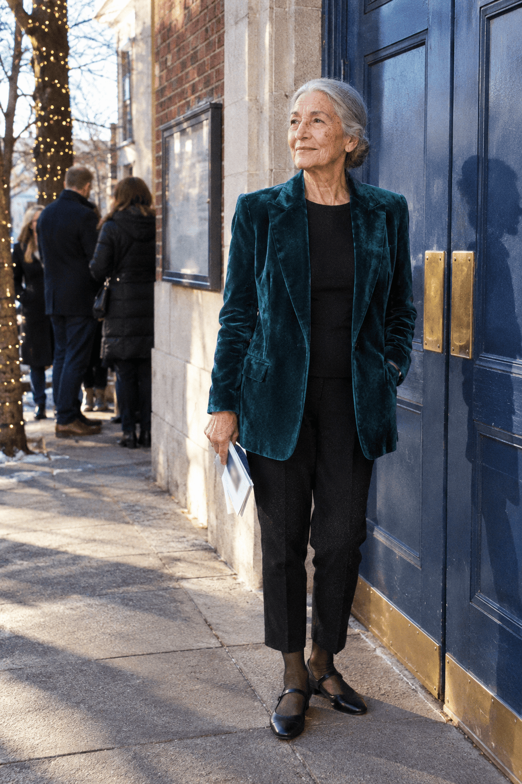elegant recital outfit for a woman in her 80s: deep teal thigh-length velvet blazer worn open, black cropped crepe trousers and black Mary Jane flats
