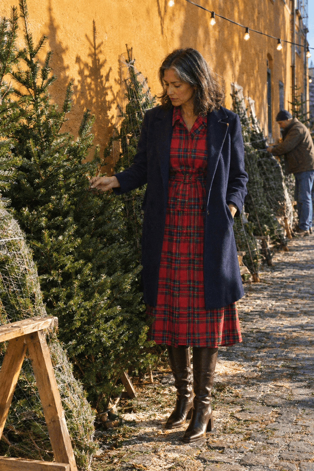 red dress winter outfit for a Christmas market: red, blue and green check collared midi dress with dark brown leather knee boots