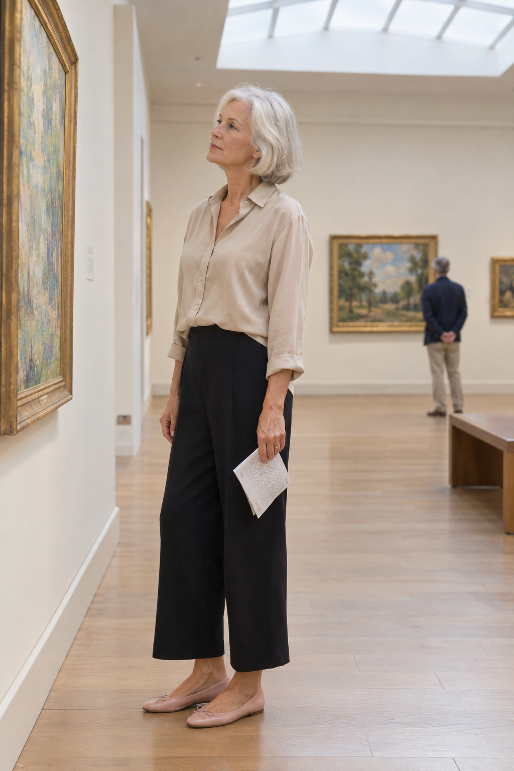 stylish spring outfit idea for older women: black wide-leg trousers with a sand silk shirt and blush ballet flats