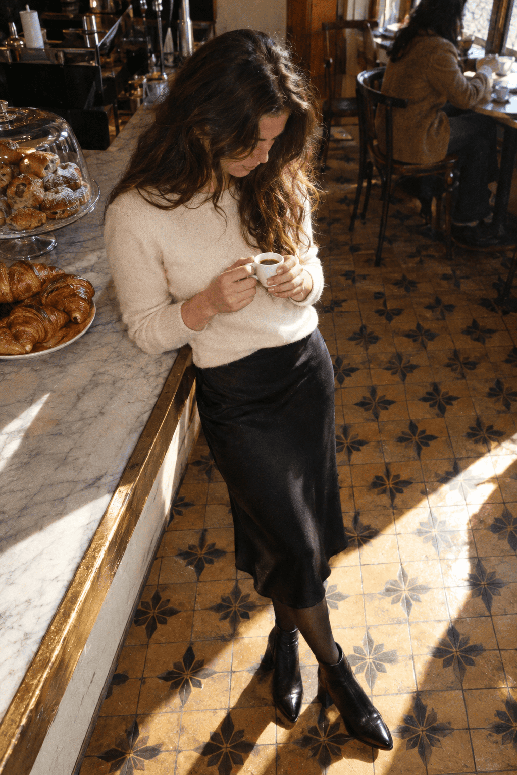 capsule wardrobe outfit for lunch: ivory cashmere crewneck with a black column slip midi skirt and black block-heel ankle boots