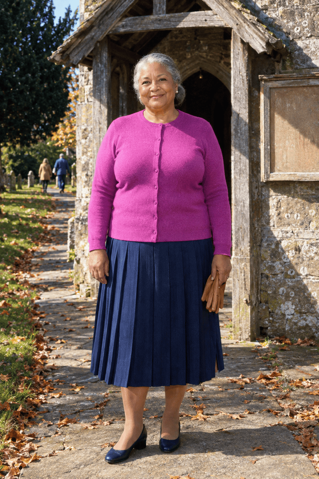 plus size church outfit for women in their 70s: bright orchid crewneck cardigan worn buttoned, navy pleated midi skirt and navy block-heel pumps