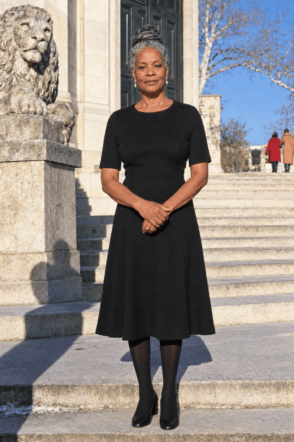 affordable elegant theater outfit for a woman in her 70s: black ponte fit-and-flare midi dress with elbow-length sleeves and black leather block-heel pumps