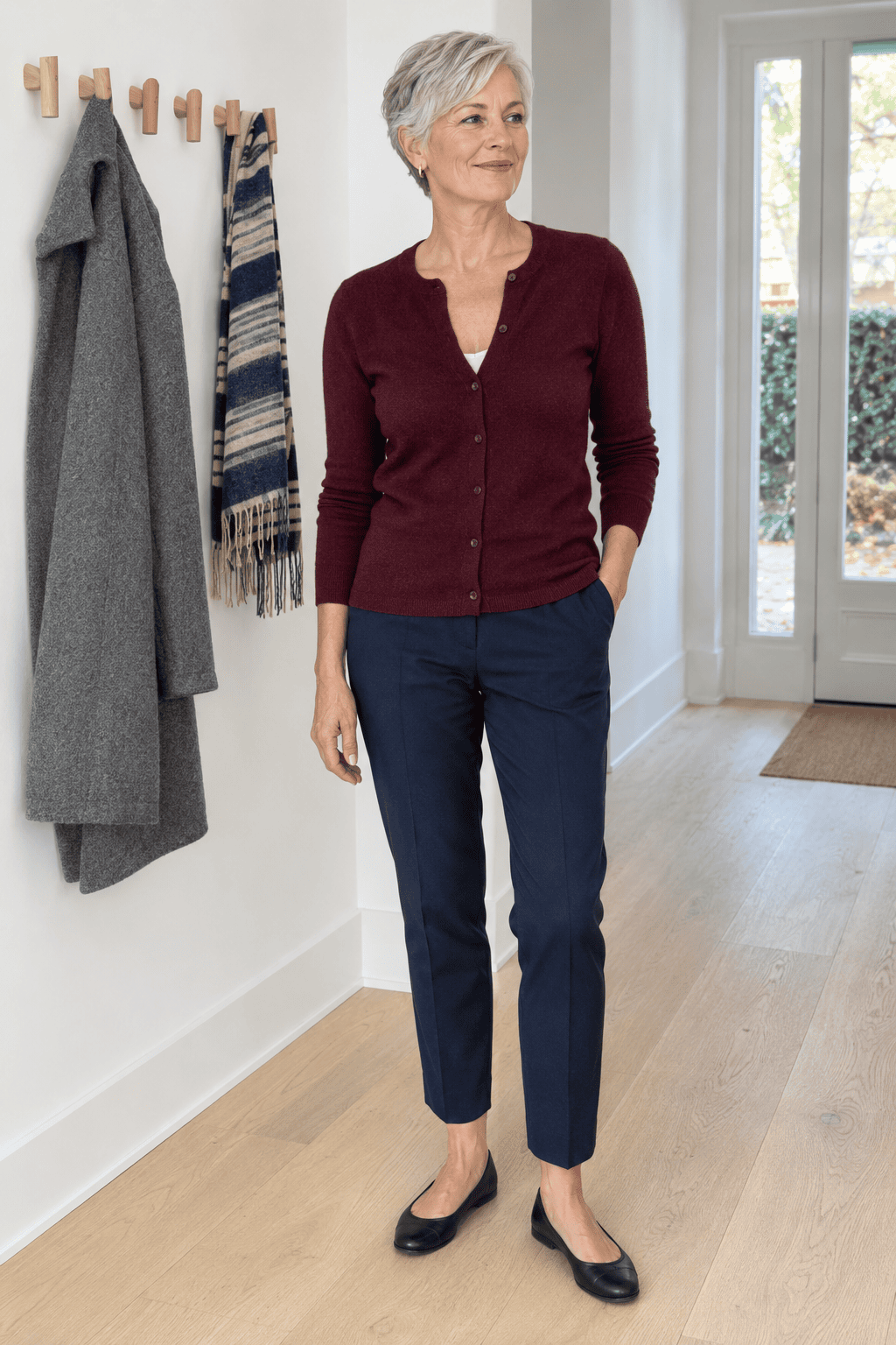 cardigan worn as a top over 60: deep burgundy cashmere crew cardigan buttoned over navy slim ankle trousers with black leather flats
