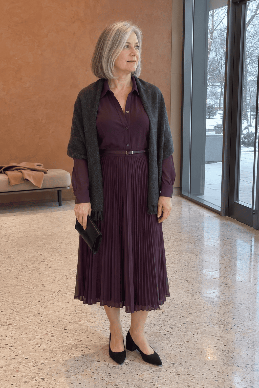 mother of the bride outfit in plum: long-sleeve pleated chiffon shirtdress to mid-calf with a charcoal cashmere wrap, black suede block-heel pumps and a black satin clutch