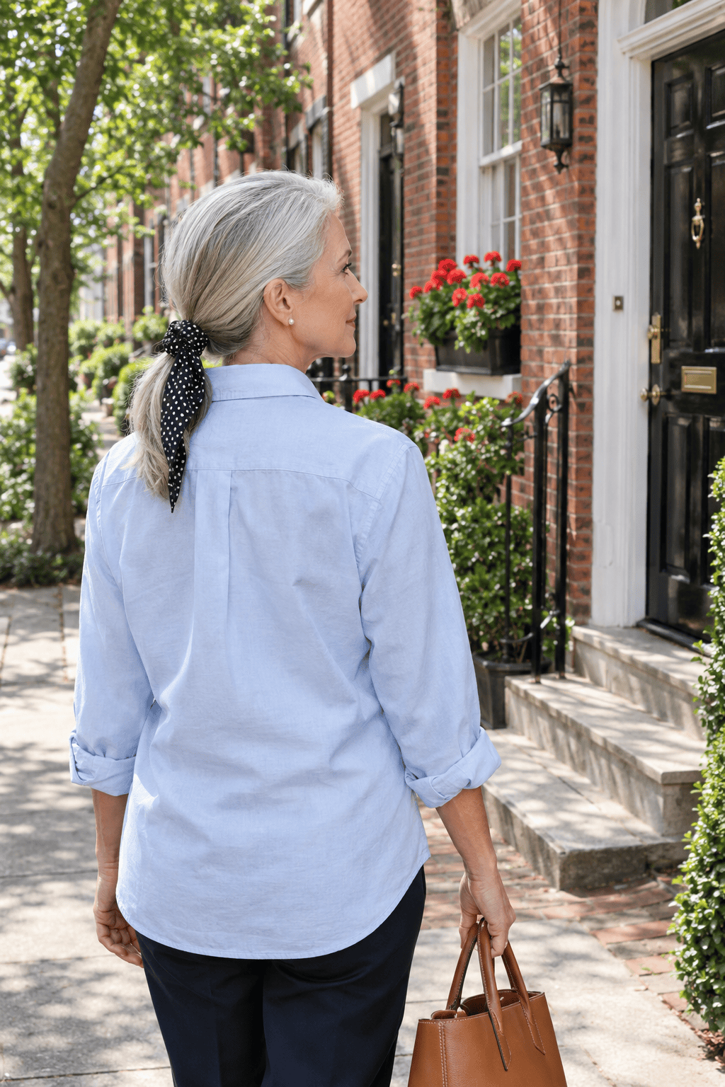 elegant hairstyles for women over 60: sleek low ponytail at the nape wrapped with a black and white silk scarf