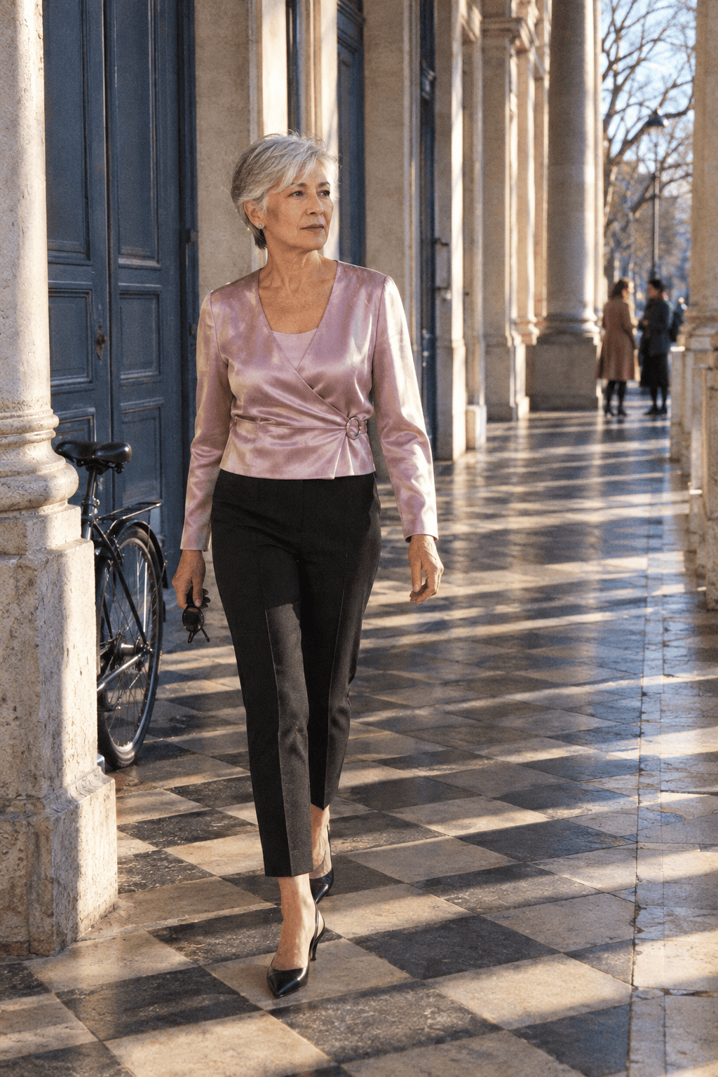 petite dinner outfit for a woman in her 70s: pale blush-lilac satin wrap top, black slim ankle trousers and black pointed kitten-heel slingbacks