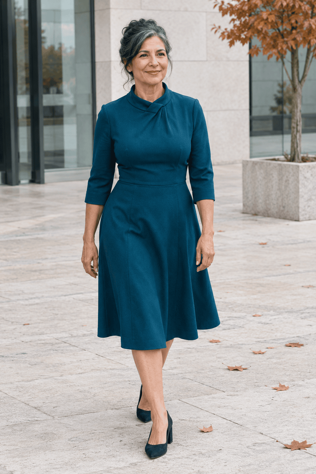 mother of the bride outfit in deep teal: twist-neck fit-and-flare dress with three-quarter sleeves, hem just below the knee, and navy suede block-heel pumps