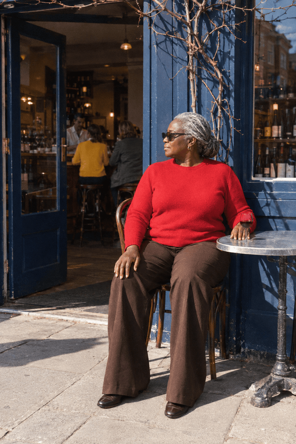 elegant plus size lunch outfit for a woman in her 70s: bright red cashmere crewneck, chocolate brown wide-leg ponte trousers and dark chocolate loafers