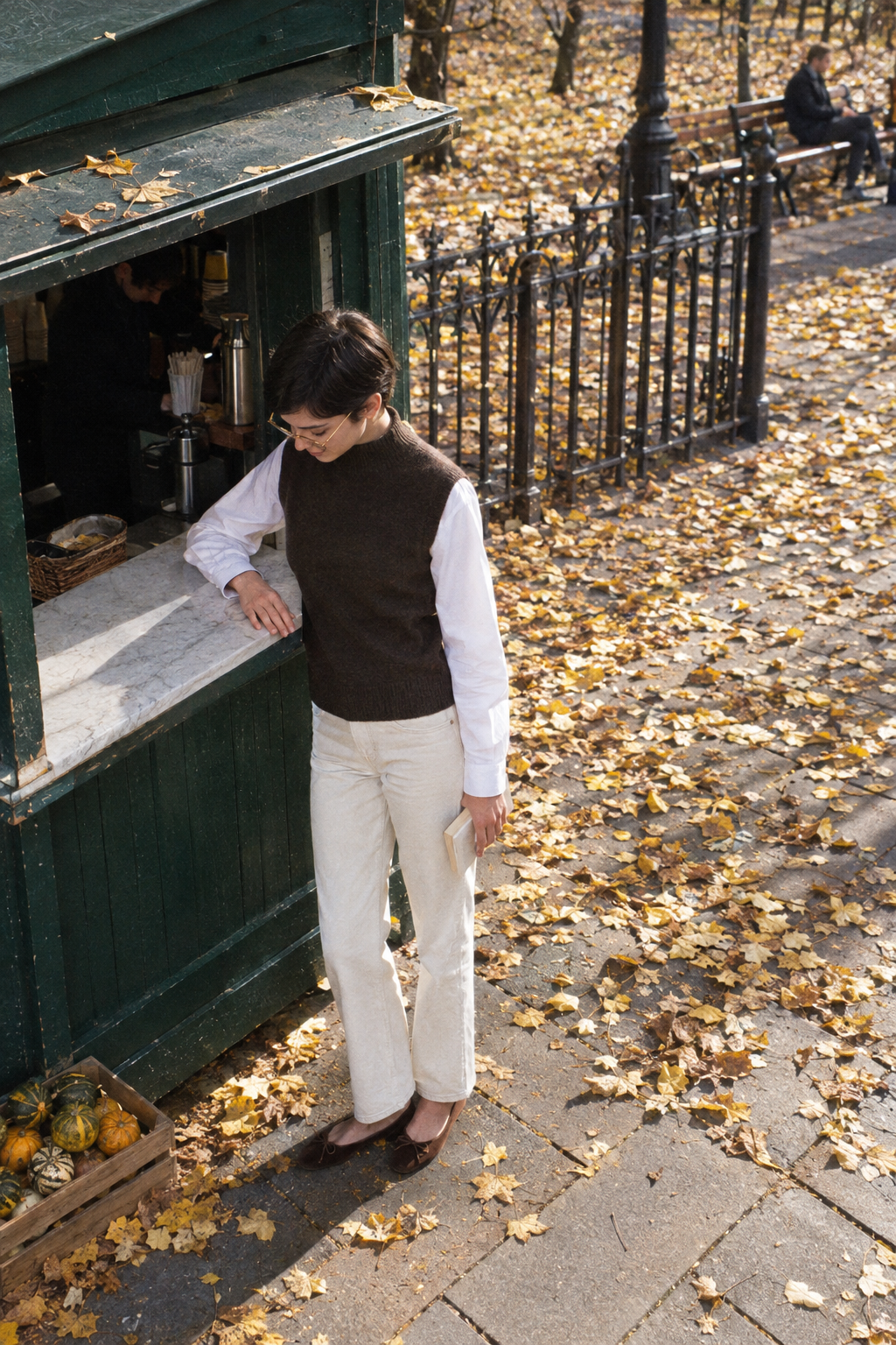 Cute Friendsgiving outfit for daytime: dark brown sleeveless mock-neck cashmere vest over a white poplin shirt, ecru straight jeans and brown suede ballet flats