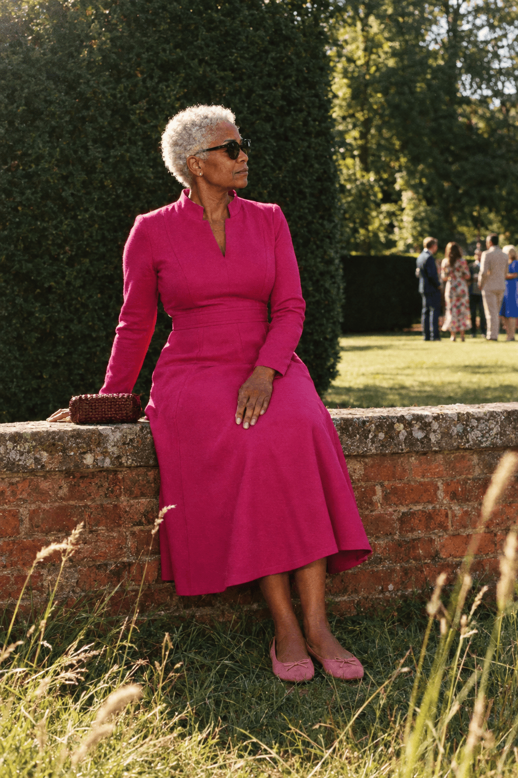 garden party wedding guest outfit for women over 70: raspberry long-sleeve ponte midi dress with soft pink suede ballet flats and a burgundy woven clutch