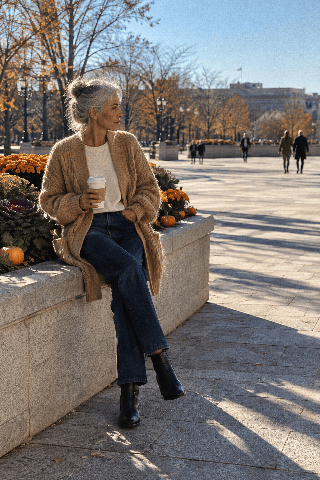women over 60 thanksgiving outfit: camel cable cardigan, dark straight jeans and black leather ankle boots