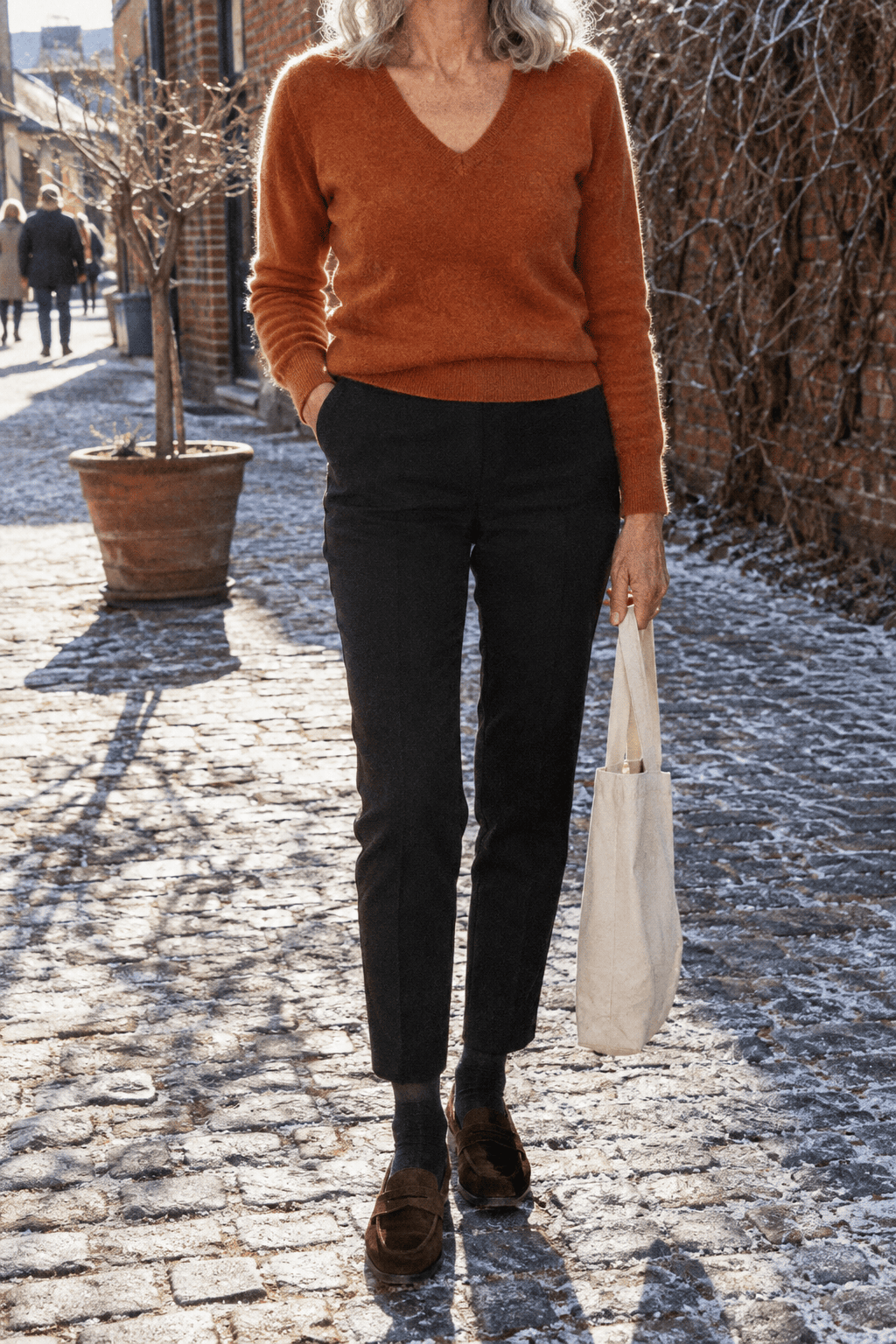 winter outfits for women over 60: warm ginger cashmere V-neck sweater, black slim ankle pants and chocolate suede penny loafers