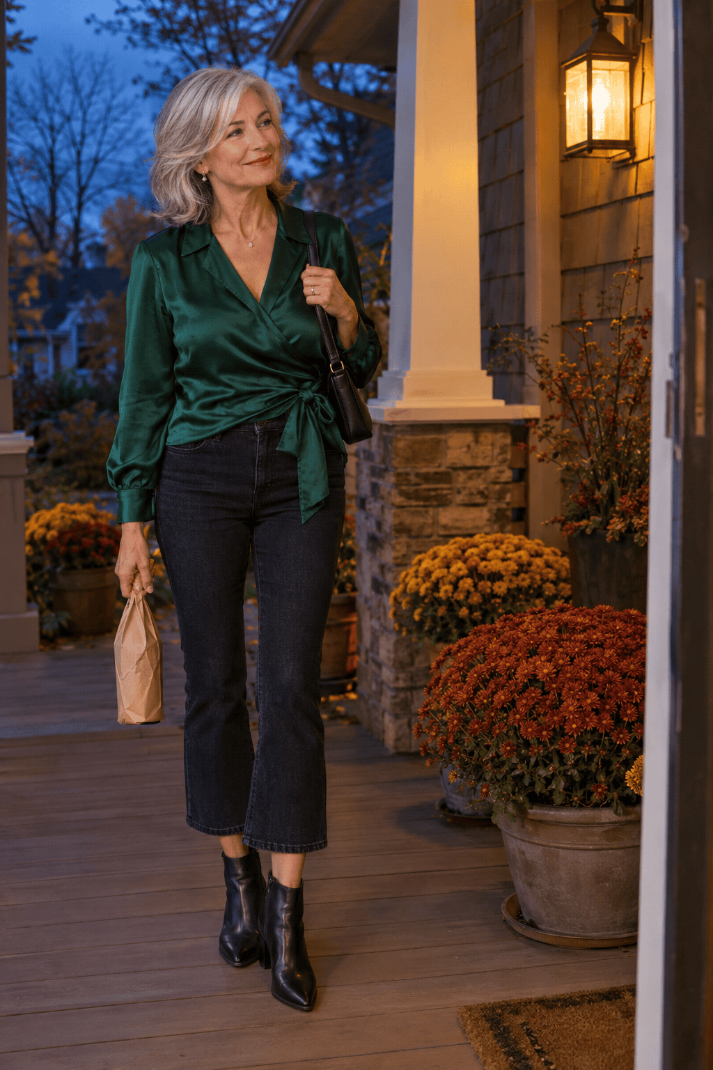petite women over 60 dinner outfit: emerald silk wrap blouse half-tucked into cropped dark kick-flare jeans with black pointed ankle boots