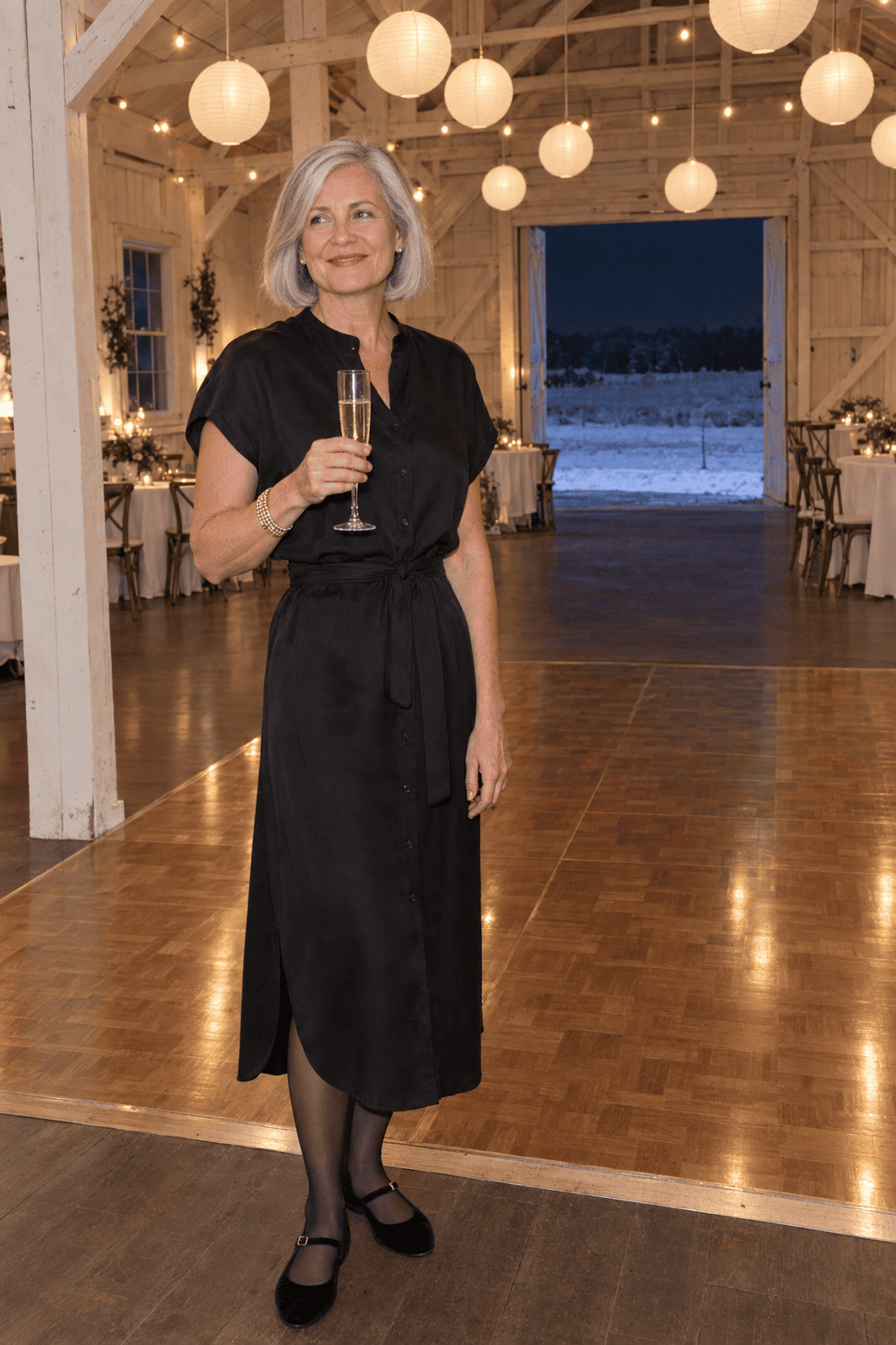 new years eve party outfit for women over 60: black silk midi shirt dress with a crystal gold bangle, sheer black tights and black velvet Mary Jane flats