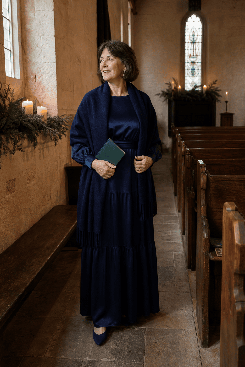 mother of the bride candlelit church winter wedding outfit: navy satin long-sleeve tiered gown, navy cashmere shawl and navy suede block-heel pumps