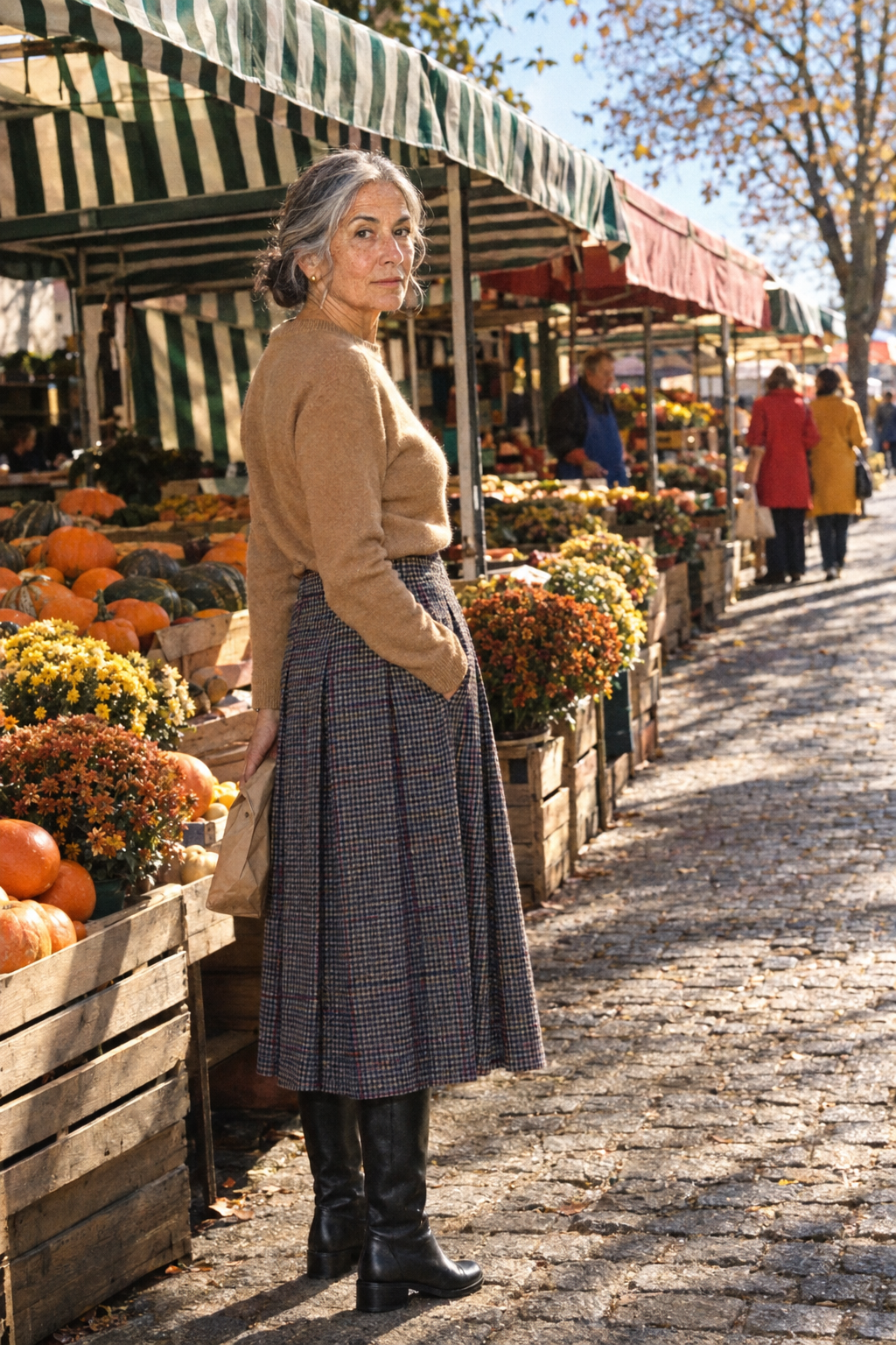 fall lunch outfit for women in their 70s: camel cashmere crewneck sweater, small dark navy-charcoal and ivory check midi skirt and tall black low-heel boots