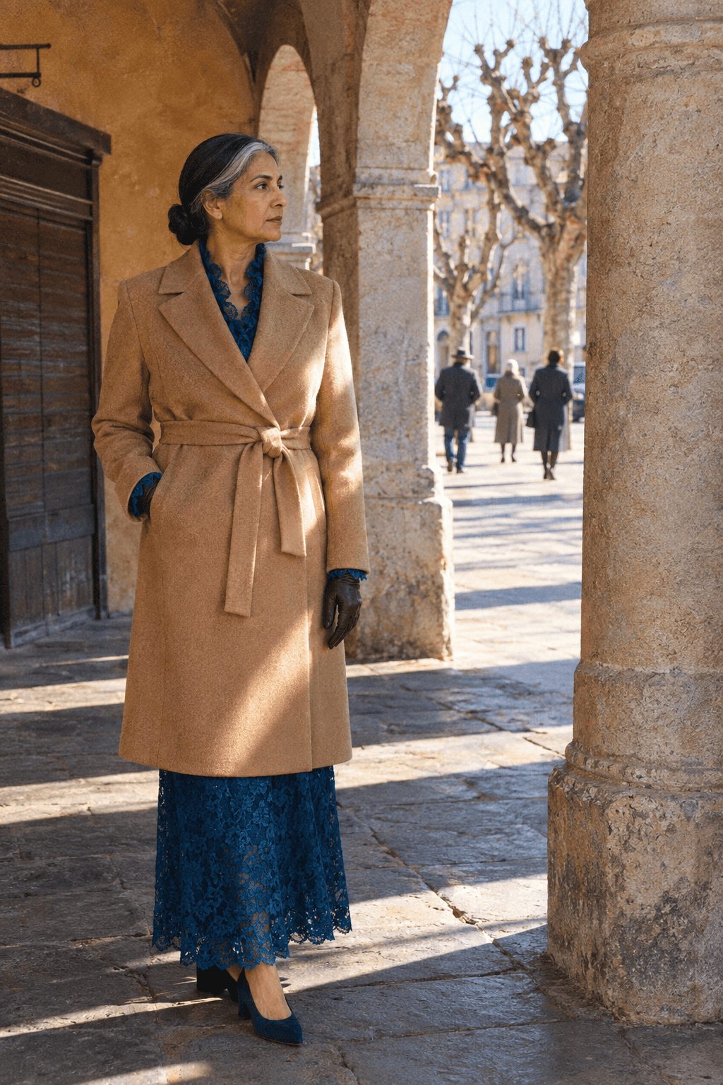 outdoor winter wedding mother of the groom outfit: ankle-length long-sleeve deep blue lace tea dress under a belted camel cashmere wrap coat with navy suede pumps