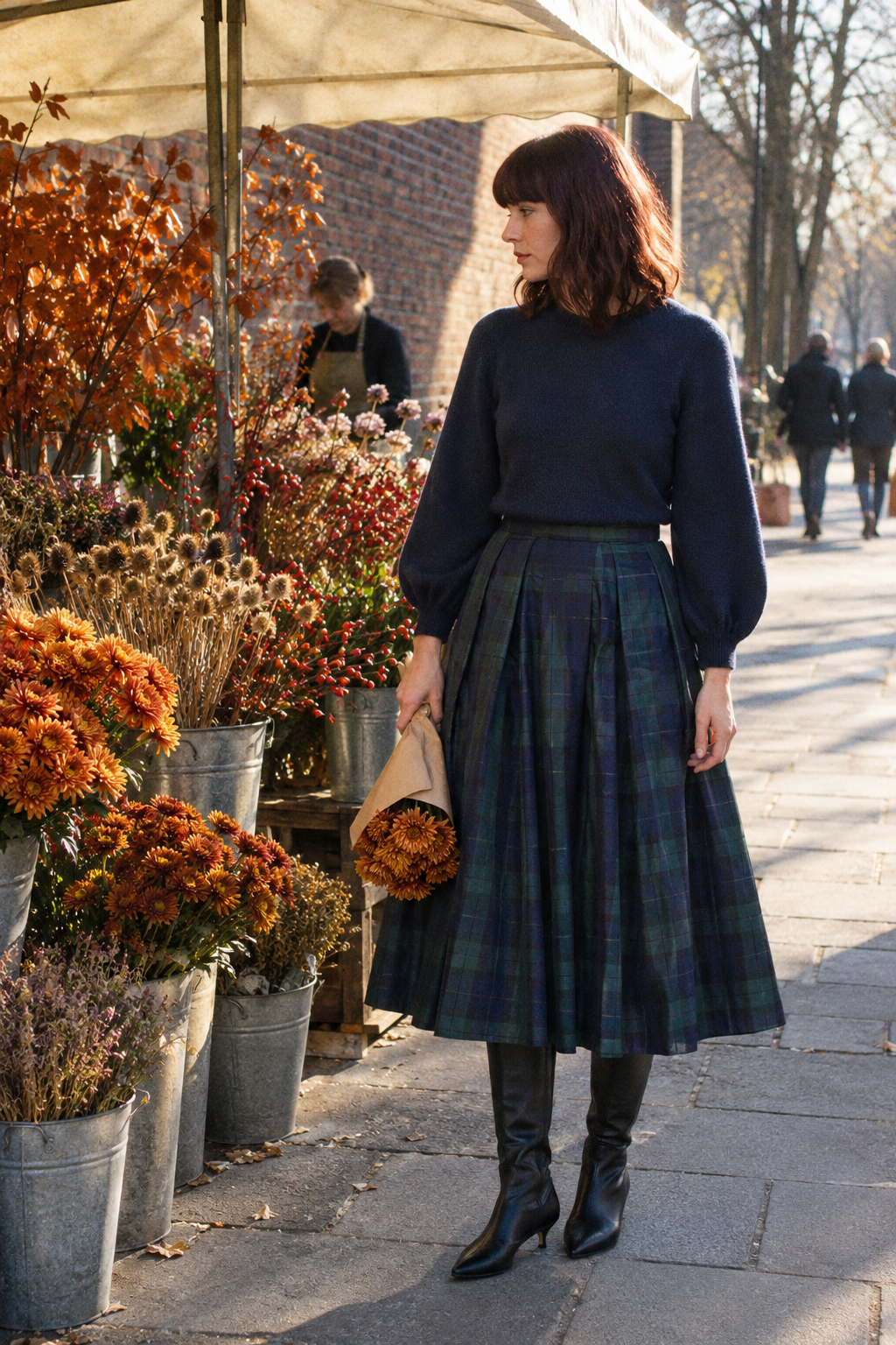 Friendsgiving dinner party outfit for evening: navy cotton crewneck, navy and green check full taffeta midi skirt and black leather knee boots