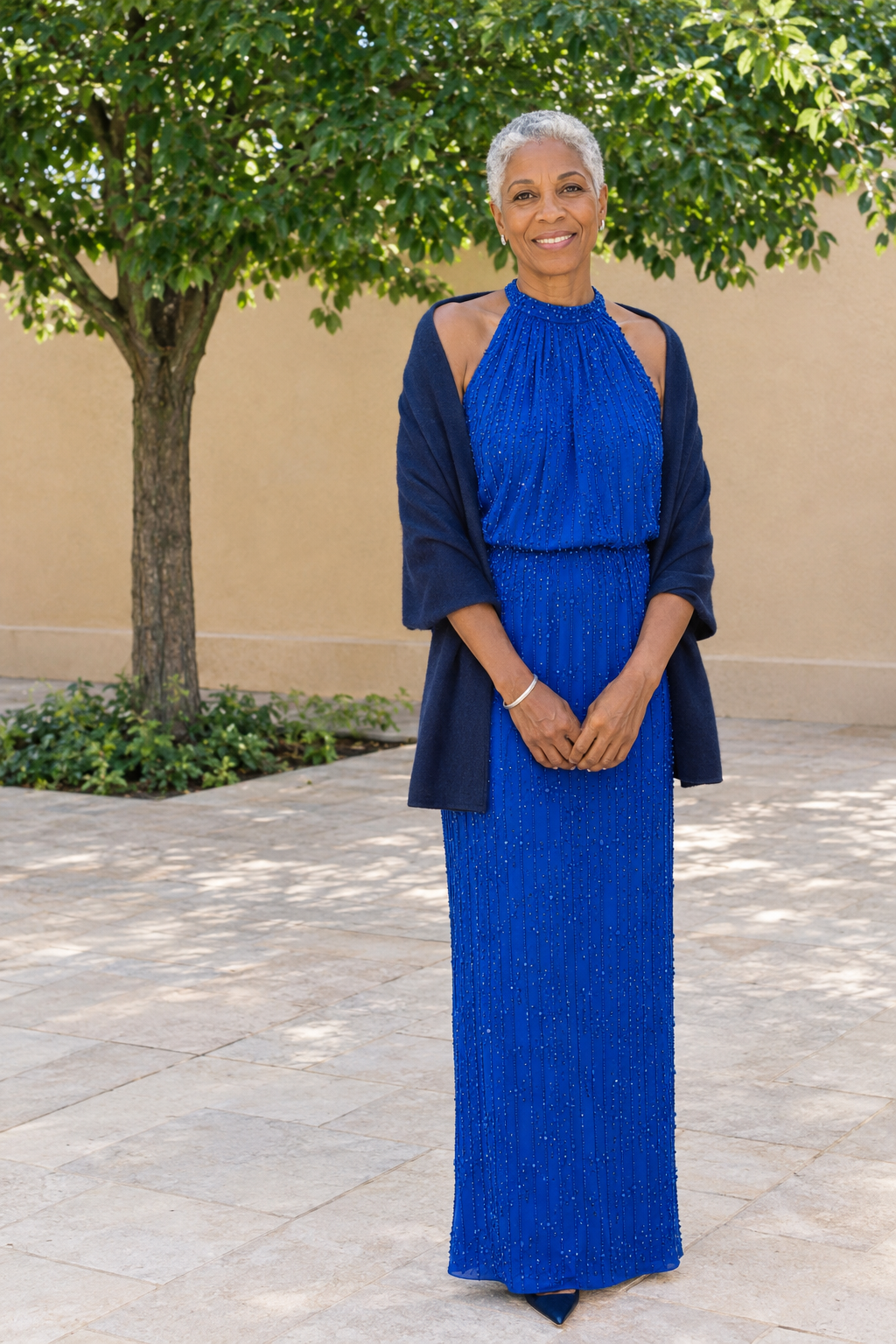 mother of the bride outfit in cobalt blue: sleeveless beaded floor-length gown with a navy cashmere wrap around the shoulders and navy kitten-heel slingbacks