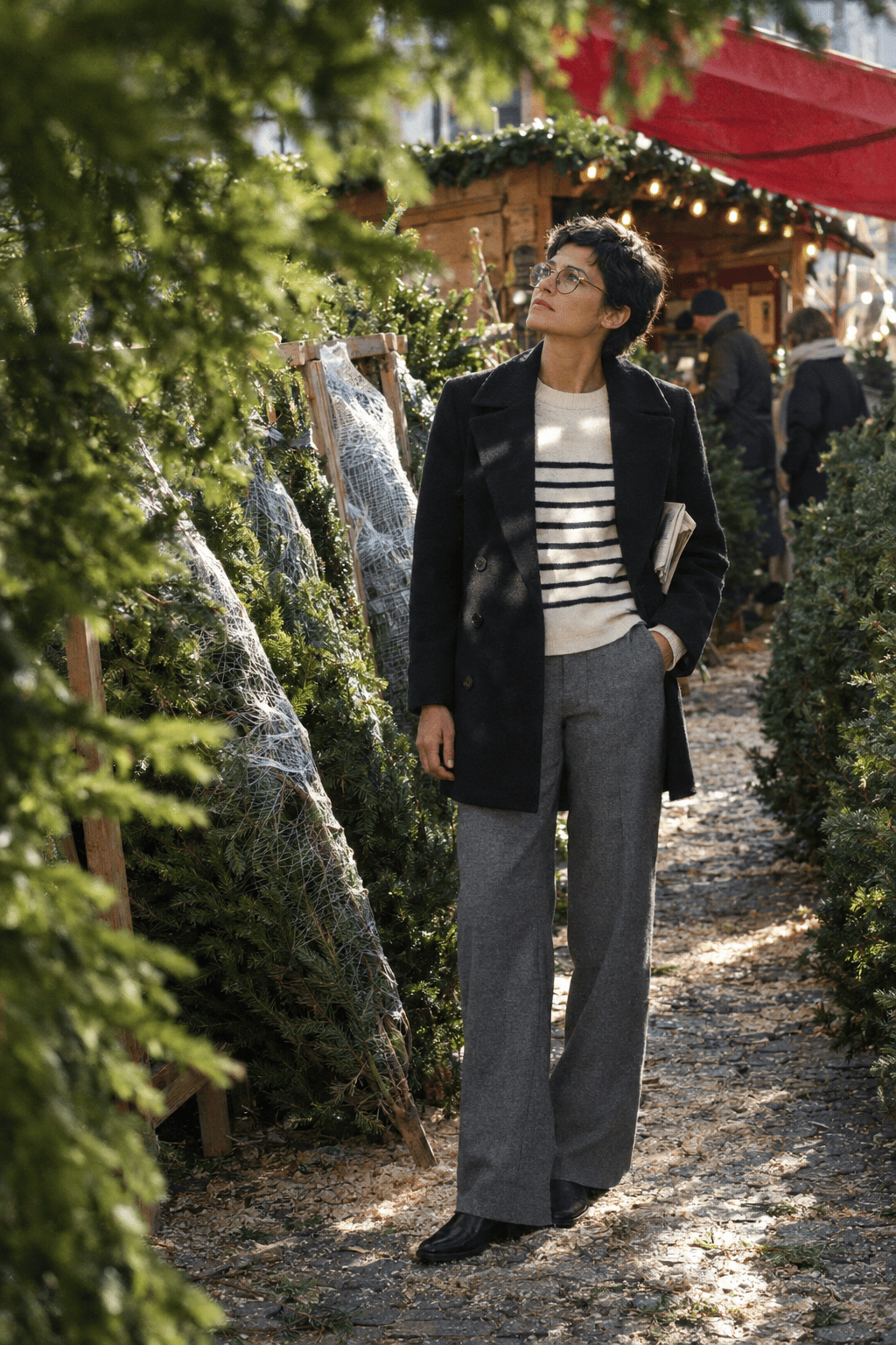 city break christmas market outfit with a black mid-thigh peacoat, ivory and navy striped sweater and grey flannel trousers