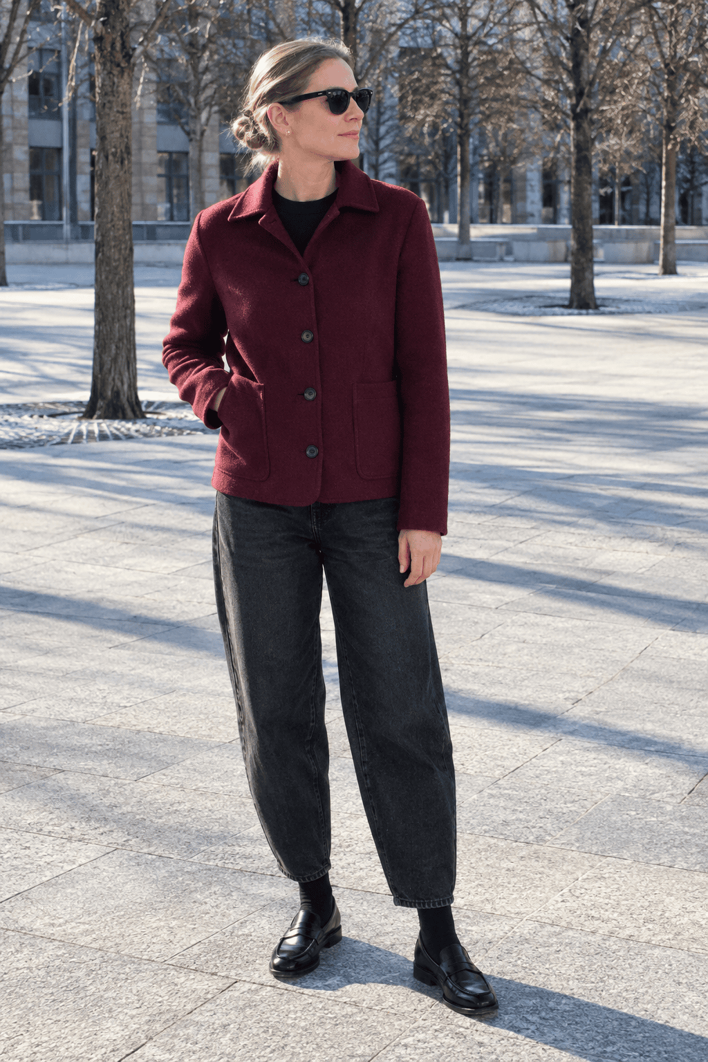 weekend city walk winter outfit for women over 40: burgundy wool jacket, black crewneck sweater, washed black barrel-leg jeans and black penny loafers