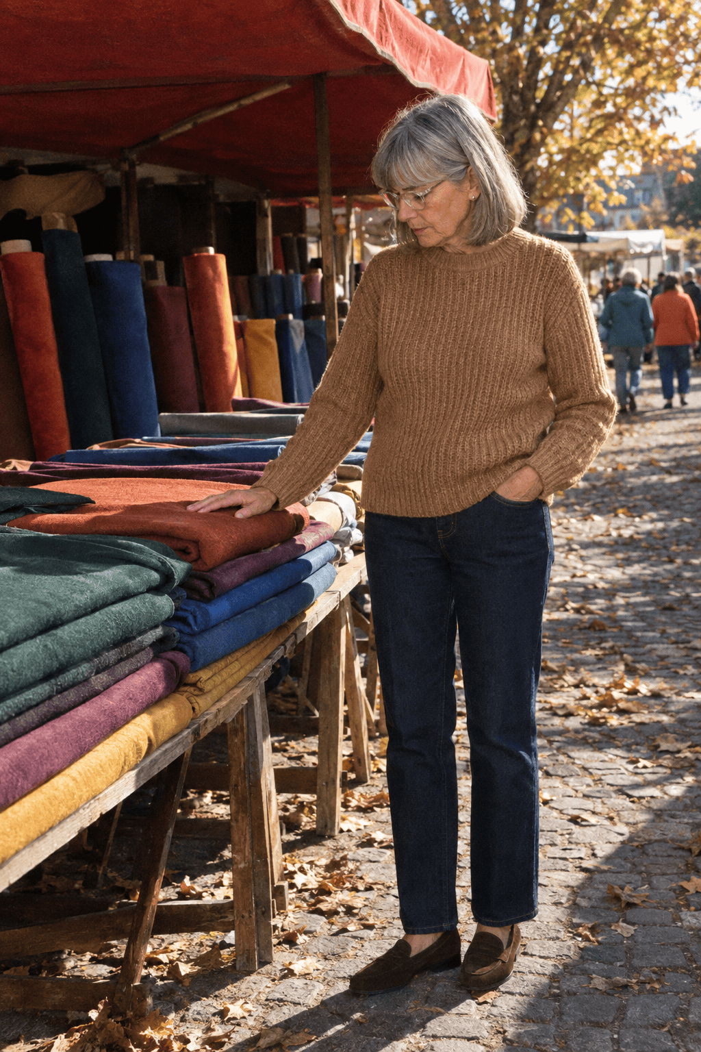 affordable casual outfit for a woman in her 70s: camel cotton fisherman-rib sweater, dark rinse straight jeans and dark brown suede loafers