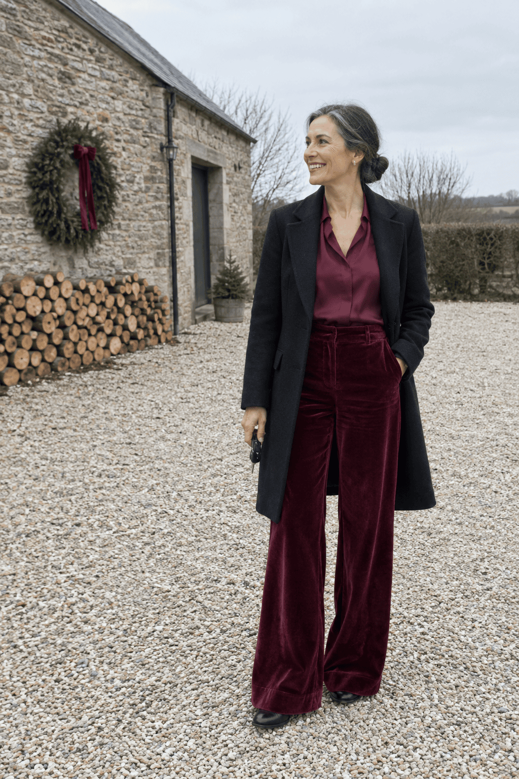 mother of the bride barn winter wedding outfit: burgundy velvet high-waisted wide-leg trousers, wine silk long-sleeve blouse and black leather block-heel ankle boots