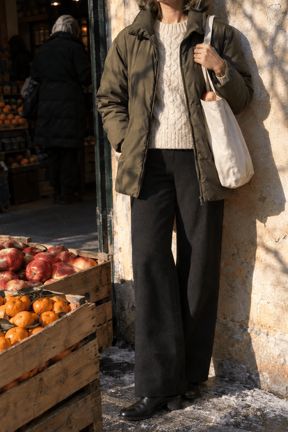 casual winter outfit: olive non-quilted down short coat, off-white cable knit sweater, black wide-leg ponte pants and black leather ankle boots