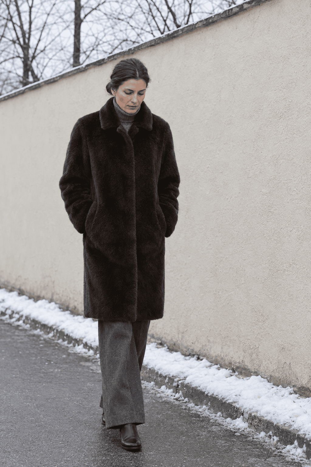 milan winter outfit old money for freezing days: dark chocolate faux fur coat, grey cashmere turtleneck, grey wool flannel trousers and black leather ankle boots