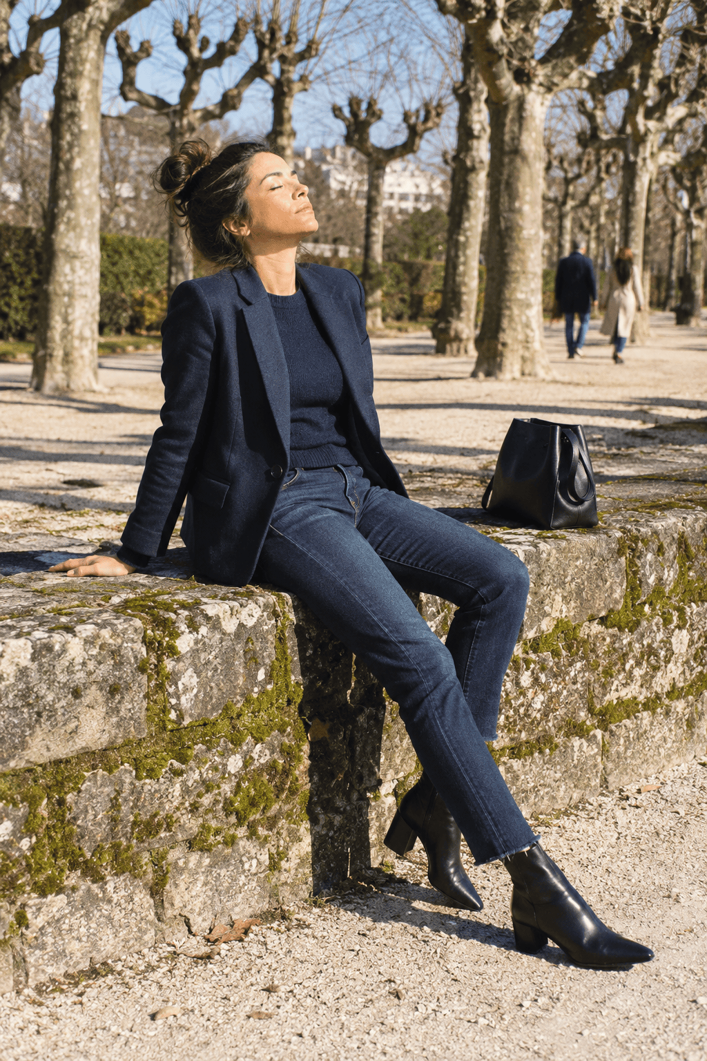 capsule wardrobe tonal outfit: navy wool blazer over a navy cashmere crewneck with dark indigo jeans and black ankle boots