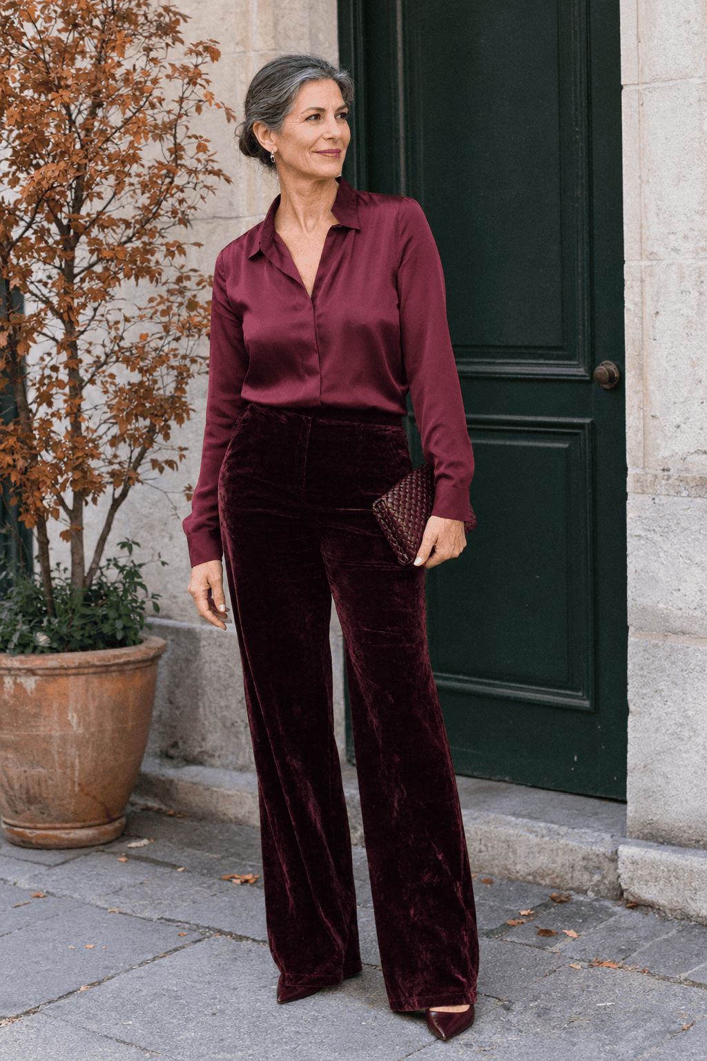 mother of the bride outfit in burgundy: wine silk long-sleeve blouse with dark cherry velvet flare trousers, wine kitten-heel slingbacks and a burgundy woven clutch