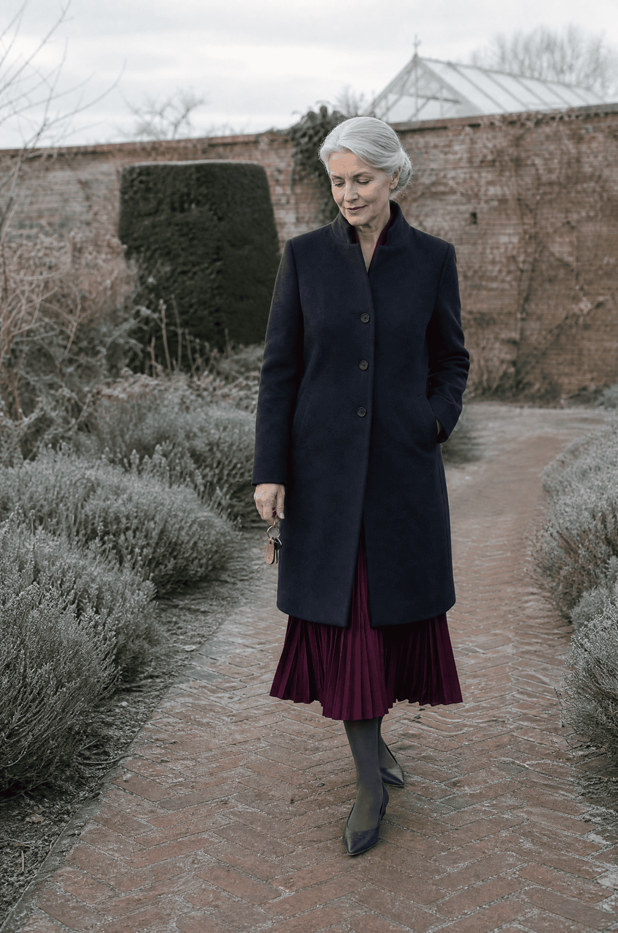 winter wedding guest outfit for women over 50: deep plum pleated chiffon long-sleeve shirtdress, navy wool coat and navy leather pointed flats