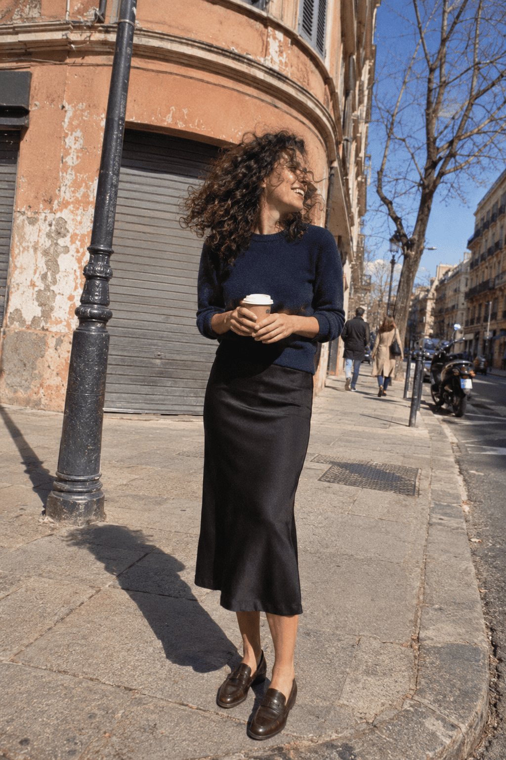 neutral capsule wardrobe gallery outfit: navy cashmere crewneck with a black column slip midi skirt and dark chocolate brown loafers