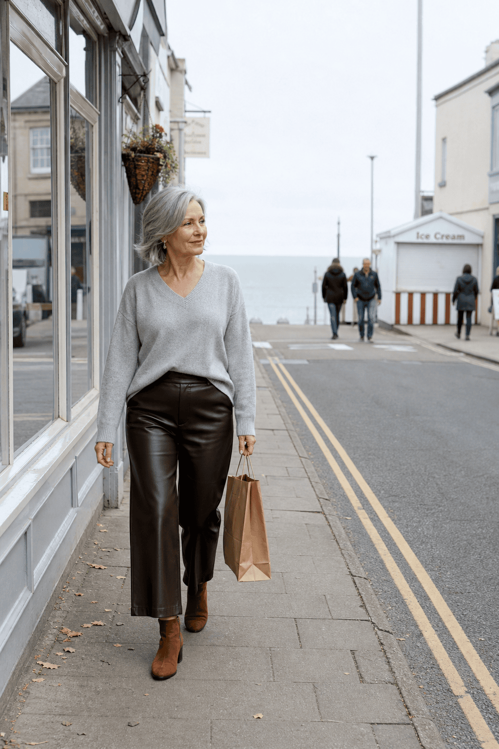 petite outfit for women over 60: gray cashmere V-neck front-tucked into espresso faux-leather cropped pants with cognac suede booties