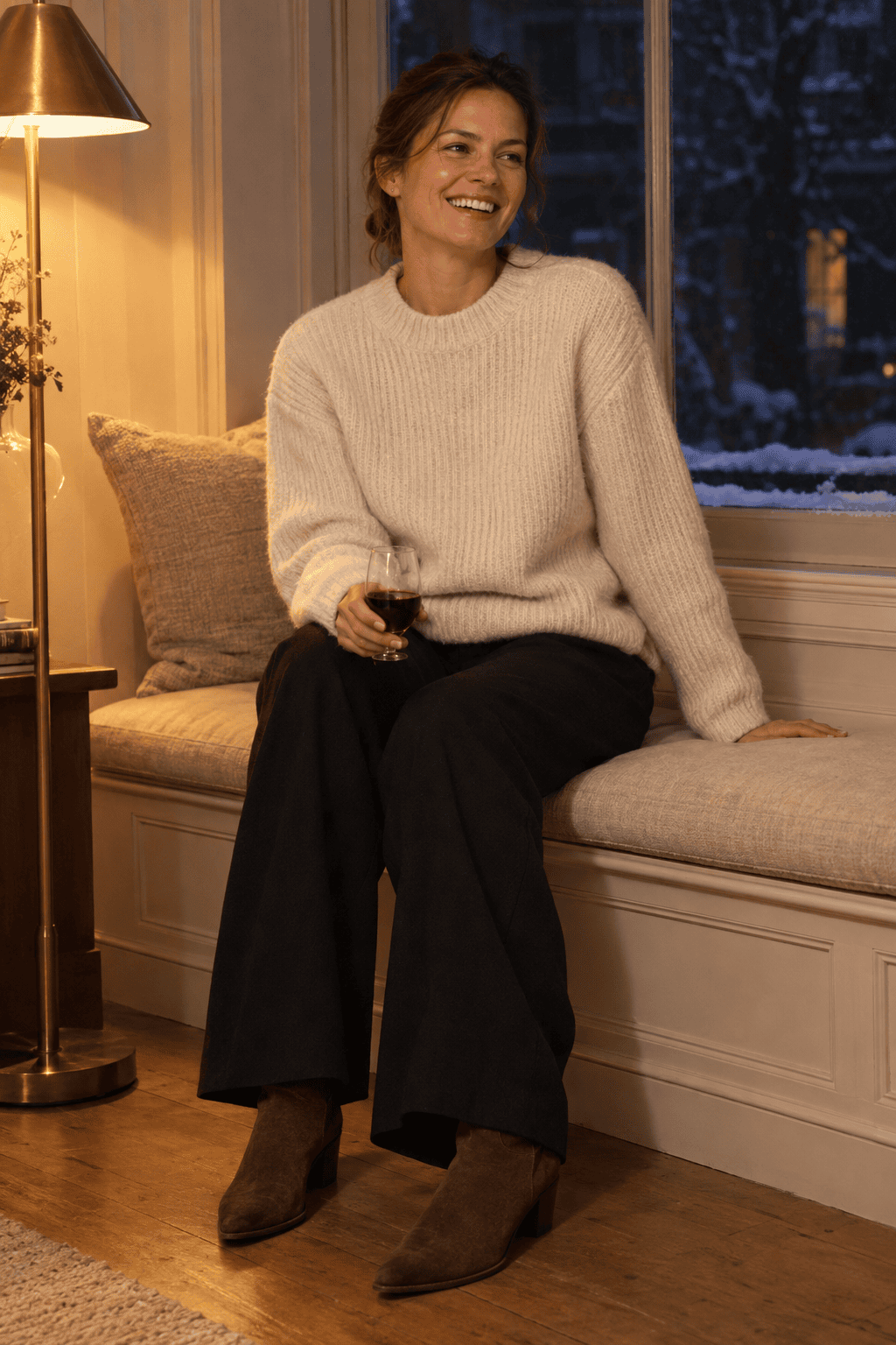 cozy winter evening outfit: ivory chunky ribbed cashmere sweater with black wide-leg wool trousers and chocolate suede ankle boots