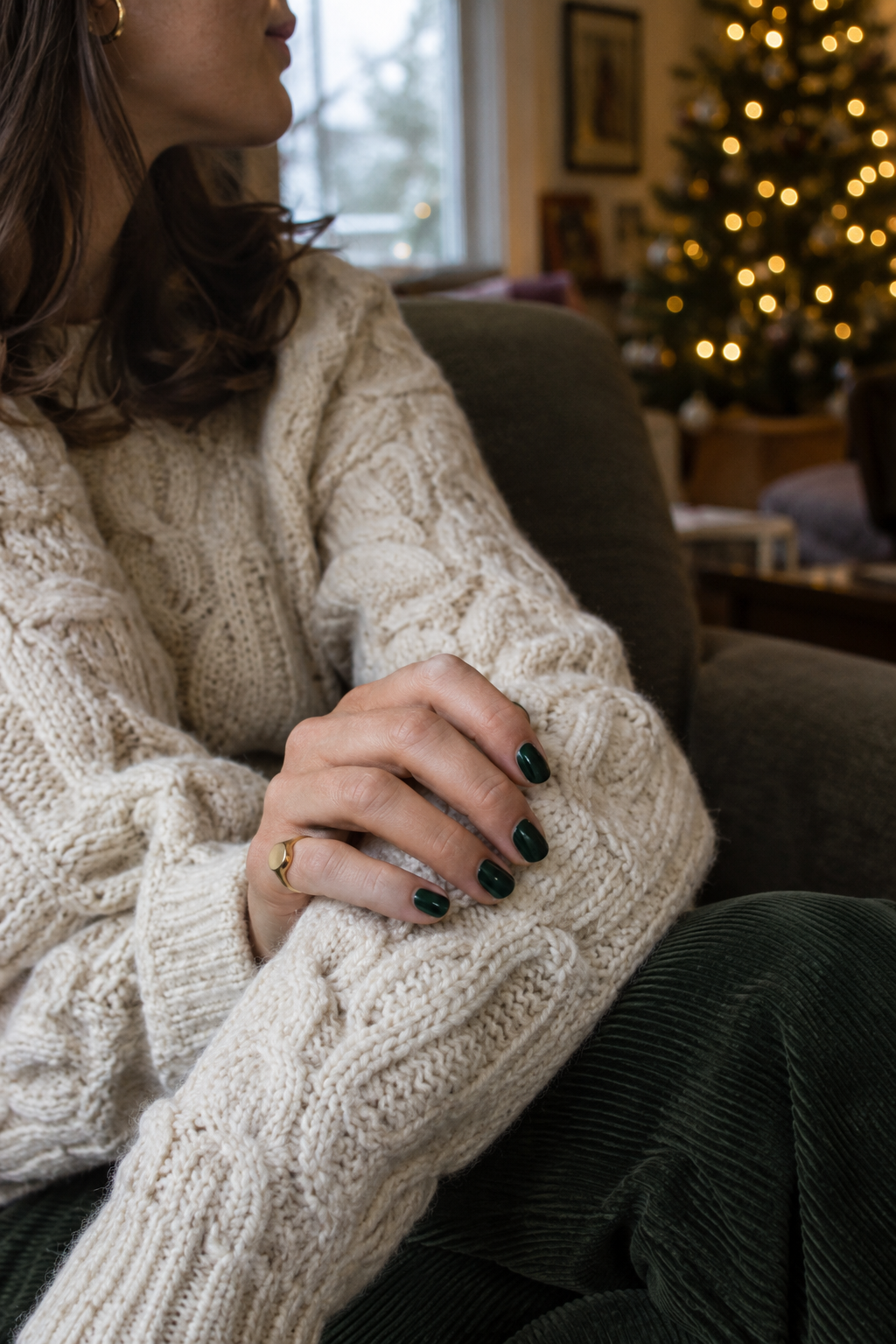 deep forest green old money christmas nails on a cream cable-knit sweater sleeve with a gold signet ring